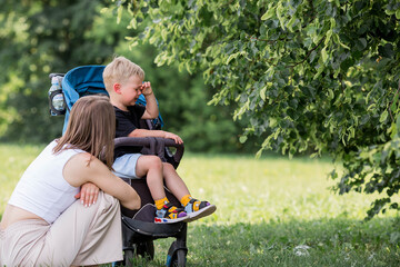 A little boy in a stroller and his mom. Childish hysteria. The child screams, cries, gets cranky...