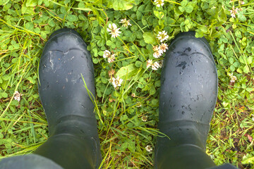 Dirty black wellingtons on the grass