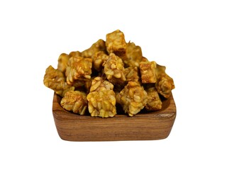 Small cube shaped fried tempeh in a square teak wood bowl, isolated on white