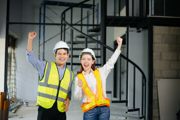 Asian engineers in safety vests and hard hats smiling on a construction site. Teamwork, pride, and professionalism in architecture