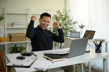 Obraz premium A Joyful, mature businessman celebrates a Career Milestone, raising his fists in triumph while smiling broadly, a Successful Business Achievement