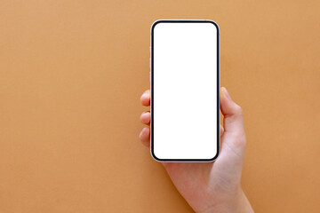 Phone with empty screen in hand, mockup on neutral beige background