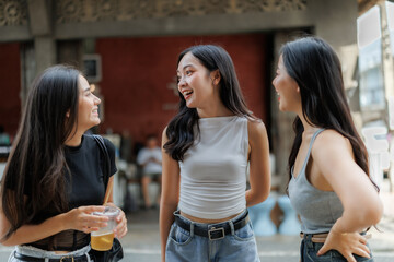 Three young women talking and laughing together outdoors