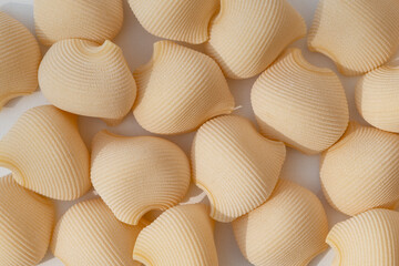  Closeup pattern of round  textured Italian wholegrain pasta on a white background.