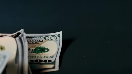 Burning pile of paper currency depicting money aflame, hundred dollar bills engulfed in bright orange flames, financial loss concept and wasteful spending, dark background