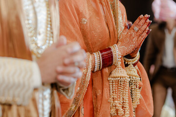 Bridal attire at a cultural wedding ceremony, adorned with intricate henna and traditional jewelry...