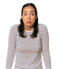 Young Filipina woman shrugs shoulders and open eyes confused.
