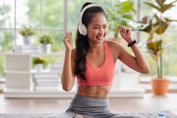 young healthy asian woman listening music while practice yoga at home