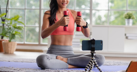 asian trainer woman live streaming online about wellness exercise at home.Influrencer marketing
