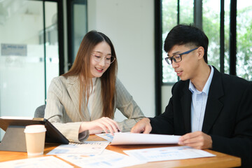 Two business people discuss financial strategy and collaborate with colleagues.