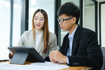 Two business people discuss financial strategy and collaborate with colleagues.