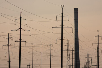 High-voltage power line in the field. Electricity pylons in the evening. Electric tower. Power transmission lines. energy security and clean energy.  