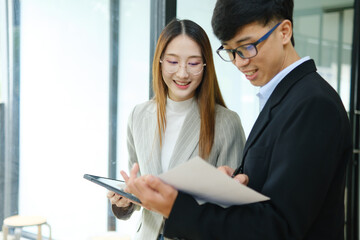 Two business people discuss financial strategy and collaborate with colleagues.