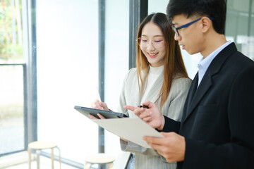 Two business people discuss financial strategy and collaborate with colleagues.