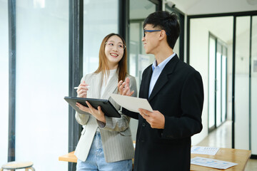 Two business people discuss financial strategy and collaborate with colleagues.