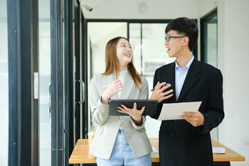 Two business people discuss financial strategy and collaborate with colleagues.