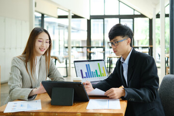 Two business people discuss financial strategy and collaborate with colleagues.