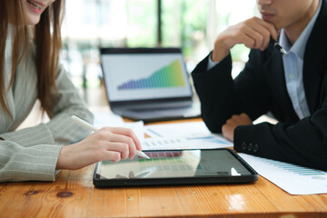 Two business people discuss financial strategy and collaborate with colleagues.