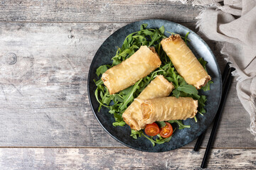Crispy vegetables spring Rolls on wooden table. Top view. Copy space
