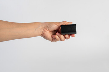 Black DSLR camera battery and hand on white background