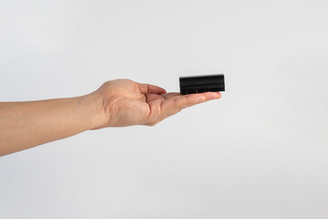 Black DSLR camera battery and hand on white background