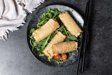 Crispy vegetables spring Rolls on black background. Top view