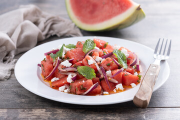 Fresh Watermelon Feta Salad with Mint and Red Onion on wooden table