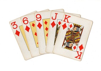A poker hand of vintage playing cards isolated on a white background.