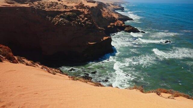 Closeup shot of the rocky coastline at Tamri sand dunes in Morocco. Arid natural desert landscape.