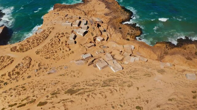 Aerial drone shot over the Tamri coastal sand dunes in Morocco.
High view of local remote village located on the coastline.
