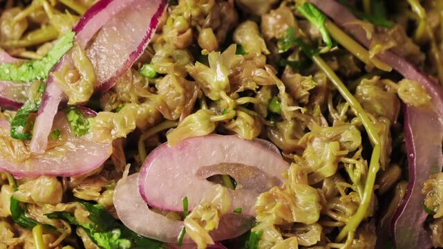 Traditional Georgian pickled. Pickled Dzhondzholi young shoots of the caper bush with flowers, drizzled with vegetable oil, sprinkled with chopped green or onion.