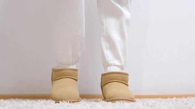 woman puts on new winter shoes touches with hands