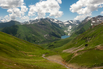 A tranquil lake nestled in lush green valleys of Himalayas in Pakistan