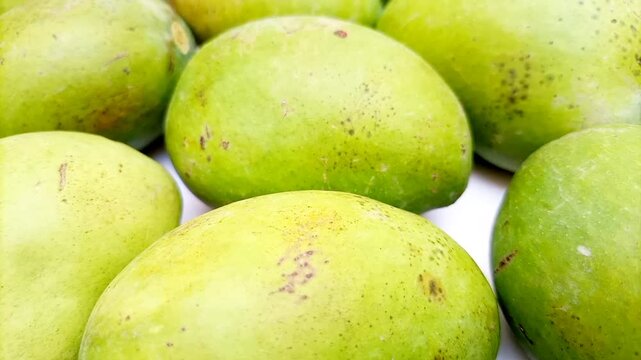 Fresh green mango fruits on white background moving, tropical fruit, unripe mangoes for pickle