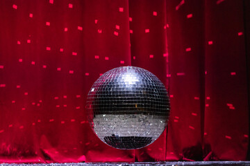 Shiny Disco Ball on a Stage with Red Curtain