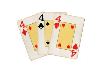 Vintage playing cards showing three of the same value on a white background.