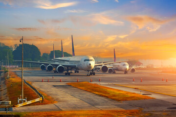 A row of old planes parked in the rays of the morning dawn in the sky