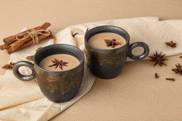 Mugs of Indian masala chai and sweets on a metal try
