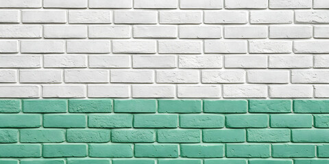 Fototapeta premium White brick wall transitioning to mint green section at bottom creating color-blocked design with clean geometric division line.