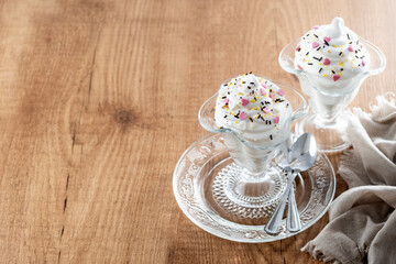 Whipped Cream Delight with Sprinkles on wooden table. Copy space