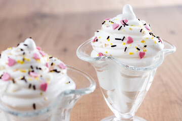 Whipped Cream Delight with Sprinkles on wooden table
