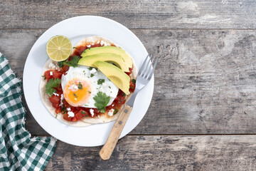 Huevos Rancheros. Traditional Mexican breakfast on wooden table. Top view. Copy space