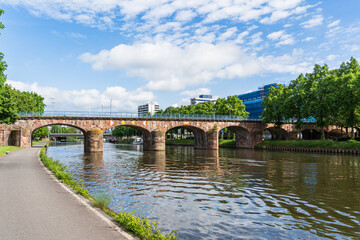 A old bridge spans a Saar river with a view of a city Saarbrucken Germany in the background