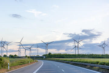 Wind turbines above highway. Sustainable energy. Eco scenery.