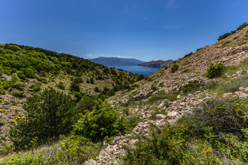 Low walls made of stone built by locals on the trail leading from Baska to Vela Luka beach,