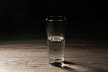 Fresh water in glass on wooden table