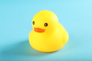 One cute rubber duck on light blue background, closeup