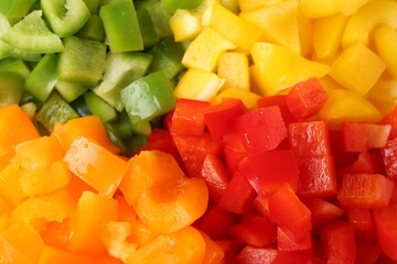 Pieces of fresh colorful bell peppers with water drops as background, above view