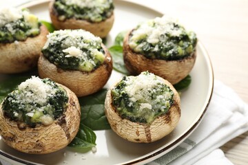 Tasty stuffed mushrooms served on light wooden table, closeup