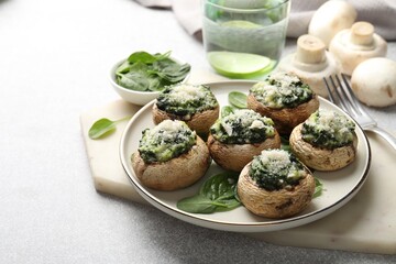 Tasty stuffed mushrooms served on light table, closeup